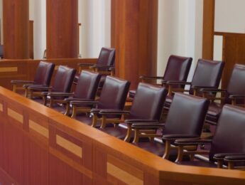 Empty jury box in a large, modern courtroom.