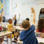 Students raising hands in classroom