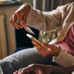 Person online shopping with credit card and phone