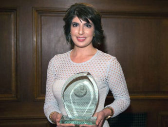 Claudine Cazian Britz holding her award