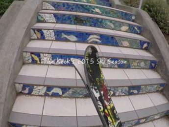 Perspective view of a person walking up outdoor stair carrying skiis with the words The Kook's 2015 Ski Season