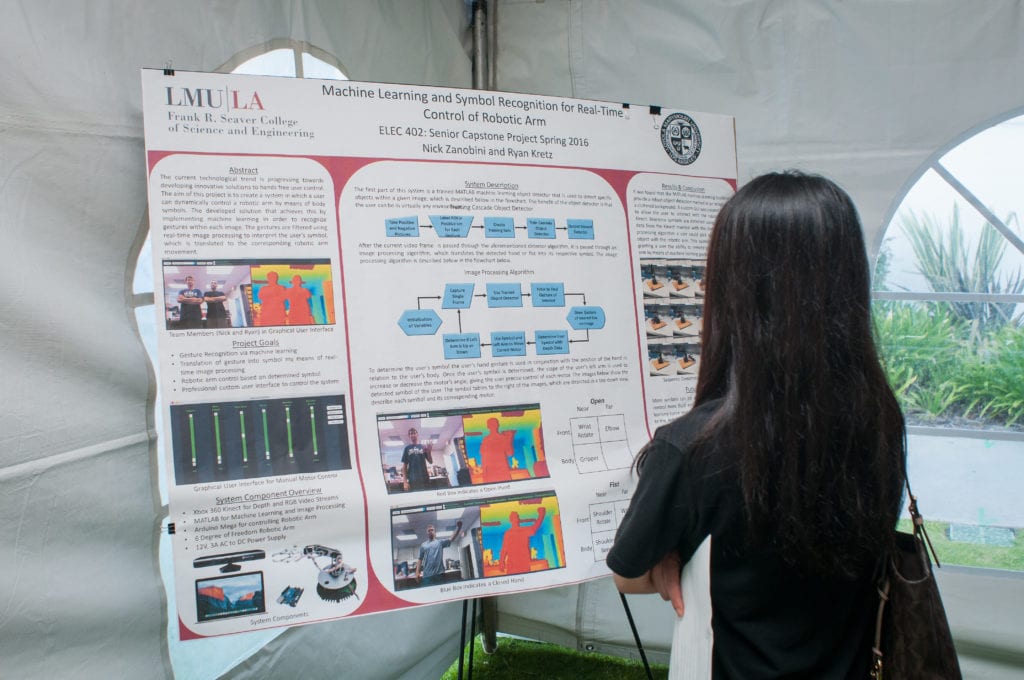 A student looking at someone's Capstone Project poster
