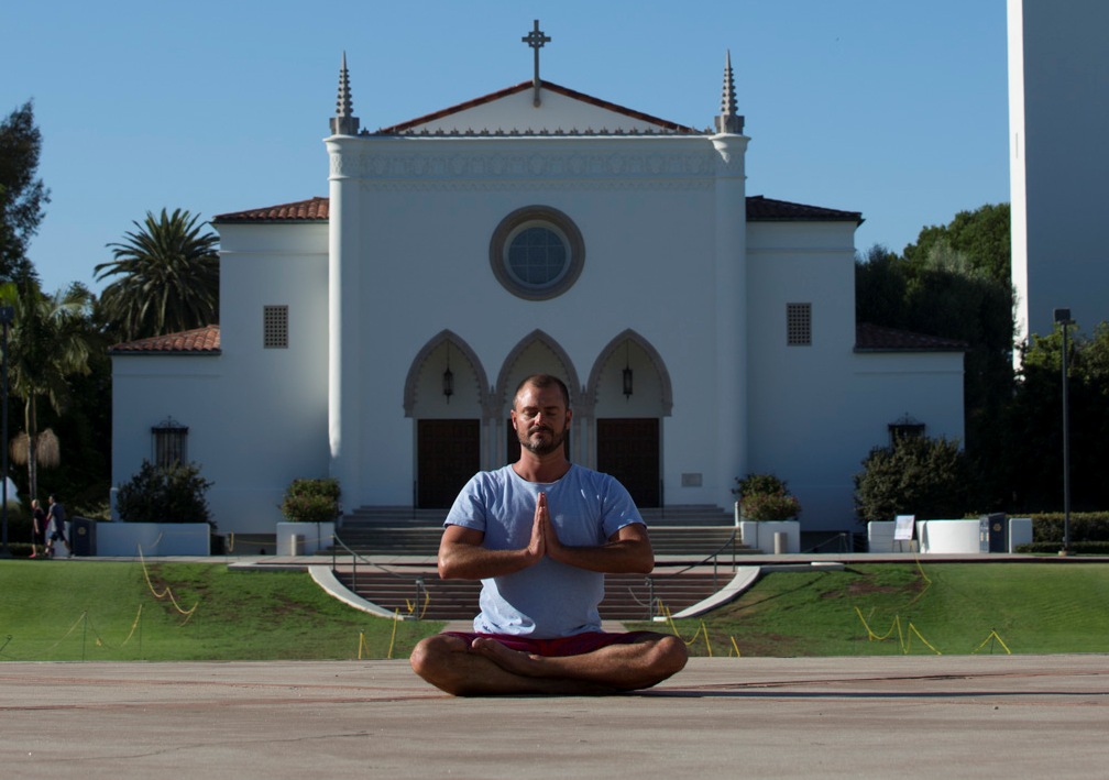 Alumni Andre meditating in front of LMU Chapel