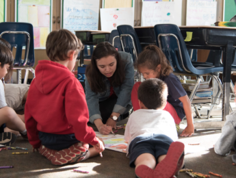 Student helping children in classroom