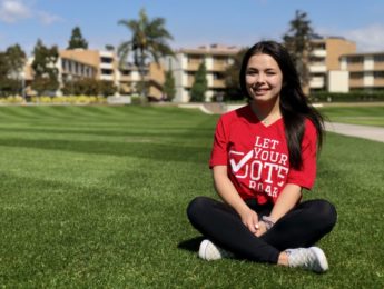 Abby Mannulang, elections committee chair sitting on the grass
