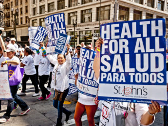 Protest with participants holding health for all signs