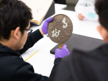 Students examine mirror from Harry Honda collection