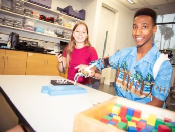 Camille Bennett (left) and Amanuel performed hand-function tests using the items shown on the table in the picture. During the testing, the students were equipped with a motion-capture system to record their joint angles, which were later analyzed for natural movement.