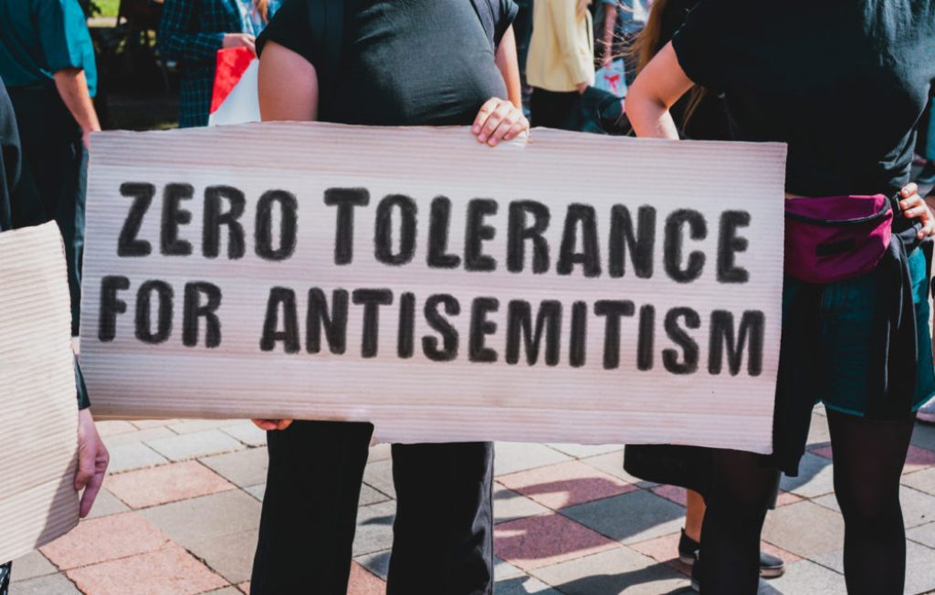Protestors against anti-semitism display a sign.