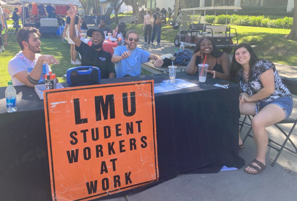 Student workers sit at a table outside at Wellness Wednesday.