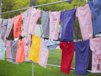 T-shirts hang on a clothesline outside on-campus to honor victims of sexual assault.