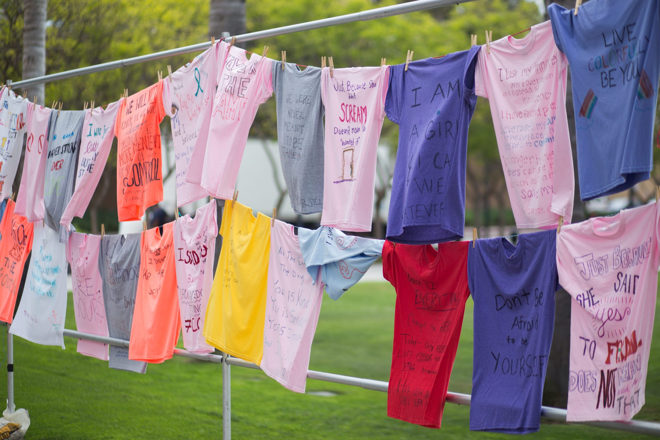 T-shirts hang on a clothesline outside on-campus to honor victims of sexual assault.