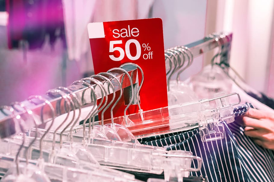 clothing rack with 50 percent off sign