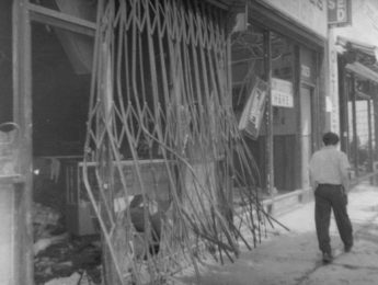 Man walking in front of damaged storefront in Los Angeles