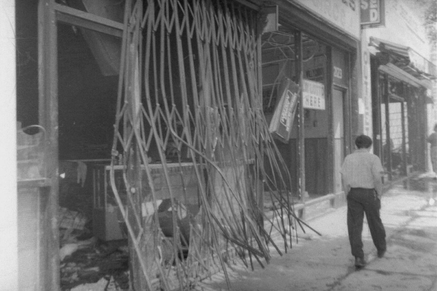 Man walking in front of damaged storefront in Los Angeles