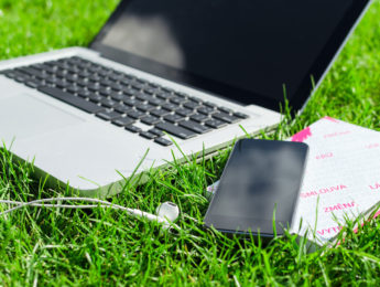laptop computer sitting in green grass