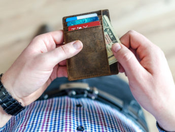 Man looking at credit cards and cash in wallet