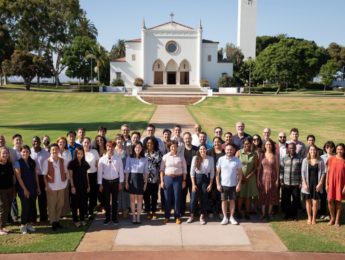 Image of new faculty standing in front of Sacred Heart Chapel