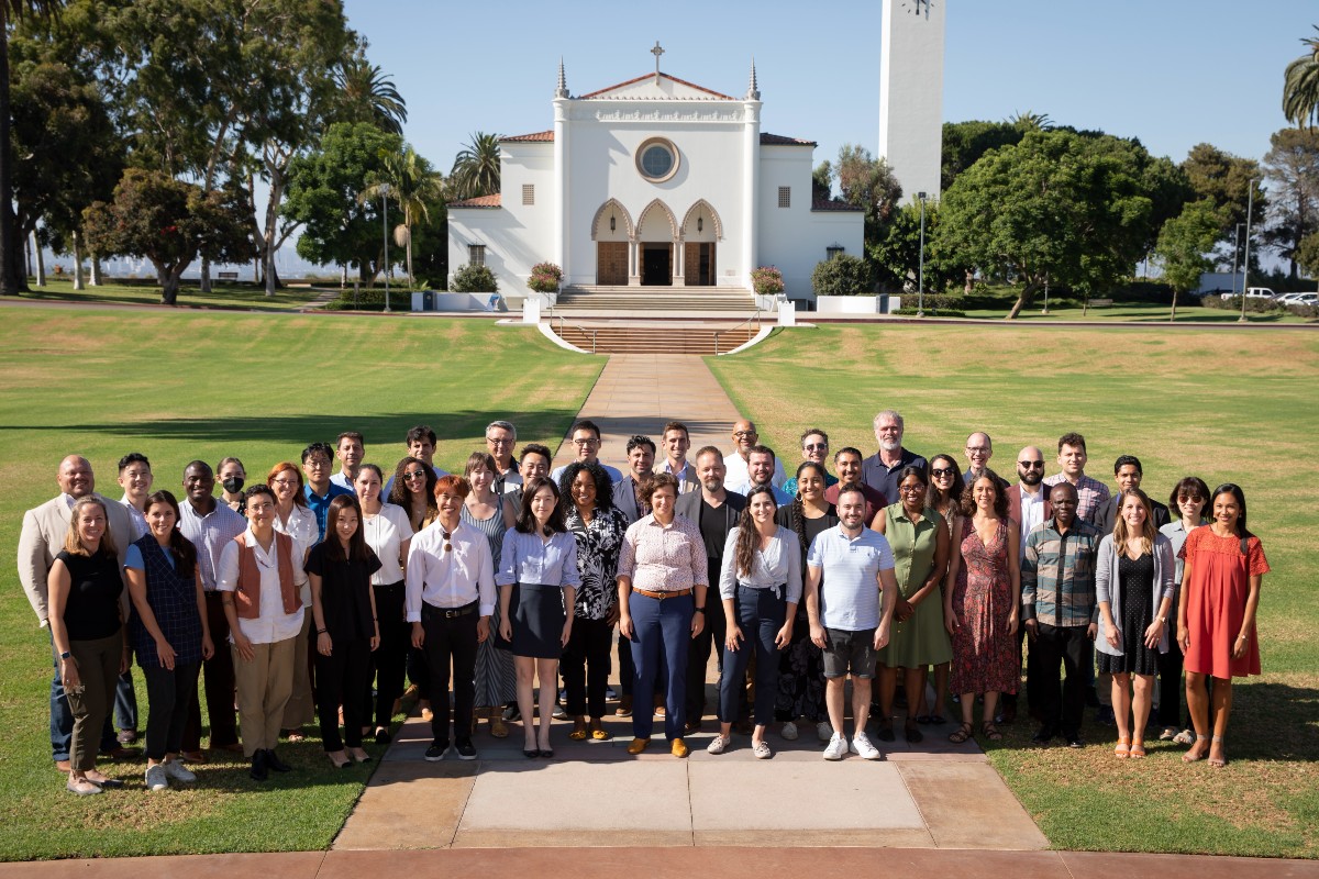 Image of new faculty standing in front of Sacred Heart Chapel