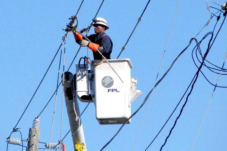 worker inspecting overhead power lines