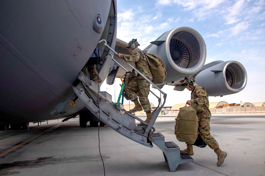 Aircrew assigned to Al Udeid Air Base, Qatar, carry their gear into a C-17 Globemaster III assigned to Joint Base Charleston, South Carolina, April 27, 2021, at Al Udeid AB. U.S. Air Force C-17s and other mobility aircraft around the U.S. Air Forces Central theater are assisting with the safe and orderly drawdown operations from Afghanistan. (U.S. Air Force photo by Staff Sgt. Kylee Gardner)