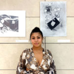 Karina Arenas '23 poses in front of her artwork in William Hannon Library.