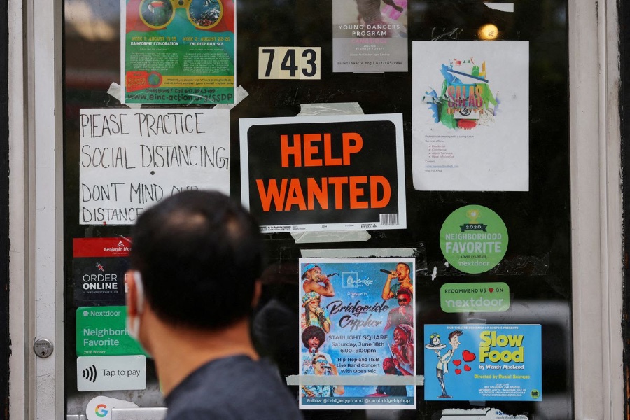 man looks at help wanted sign