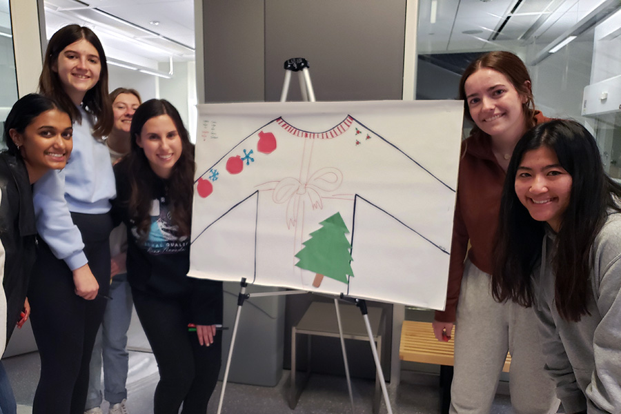 Students posing by a festive poster