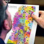 Rep. Dan Eubanks, a Republican in the Mississippi state House of Representatives, examines a copy of the House redistricting map. Associated Press: Rogelio V. Solis