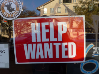 Help Wanted sign in window of business