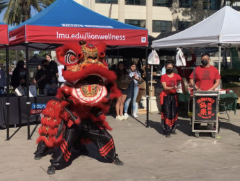 A traditional red Lion dancing outside on campus.