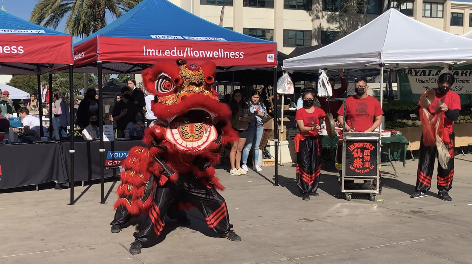 A traditional red Lion dancing outside on campus.
