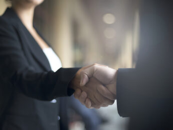Two people shaking hands on business event.