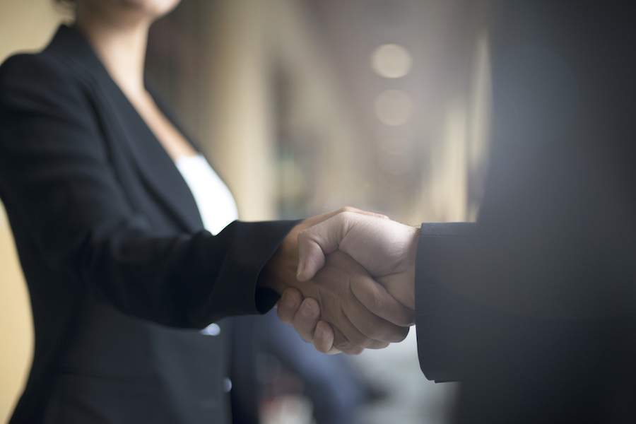 Two people shaking hands on business event.