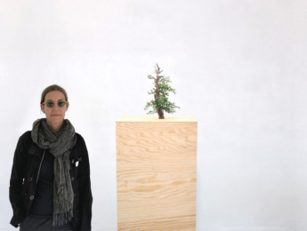 LMU professor Jane Brucker stands with "Lone Tree" sculpture by colleague, Jörg Obergfell.