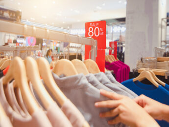 Big sale tag announcement at clothes shop, Looking for brightly colored clothes on hangers, Choose to buy clothes.