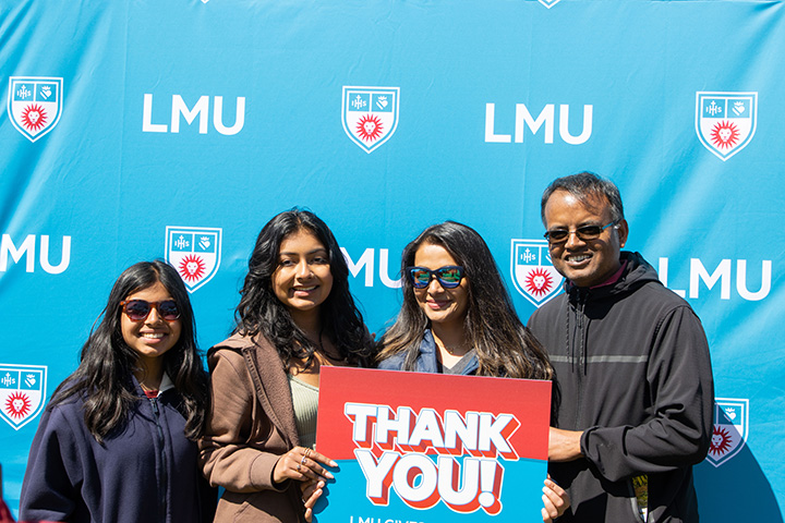 An LMU family holding up a sign saying Thank You