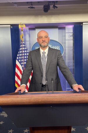 Professor Justin Levitt poses in the White House press room. 