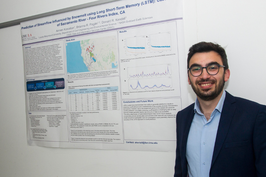 A student smile standing next to the poster board for their project titled 'Prediction of Streamflow Influenced by Snowmelt Using Long Short-Term Memory
