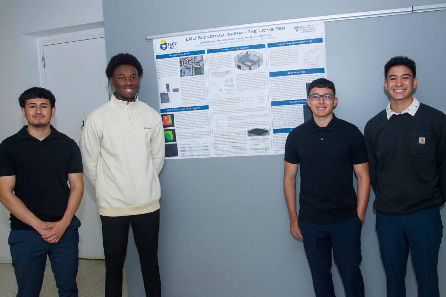 Four students smile standing next to the poster board for their project titled 'LMU Basketball Arena - The Lion's Den'
