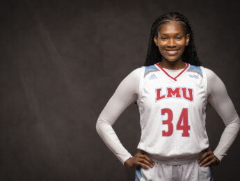 Kharial Clark smiles for a portrait picture wearing her basketball jersey