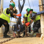 workers in vests repairing a bridge