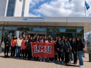 The First to Go Abroad group pose with the LMU flag in front of the UN's Bonn campus.