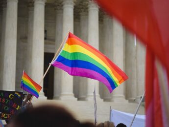rainbow flag flying in front of Supreme Court building