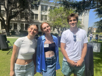 A group of three students pose for a photo outside during the Transfer BBQ.