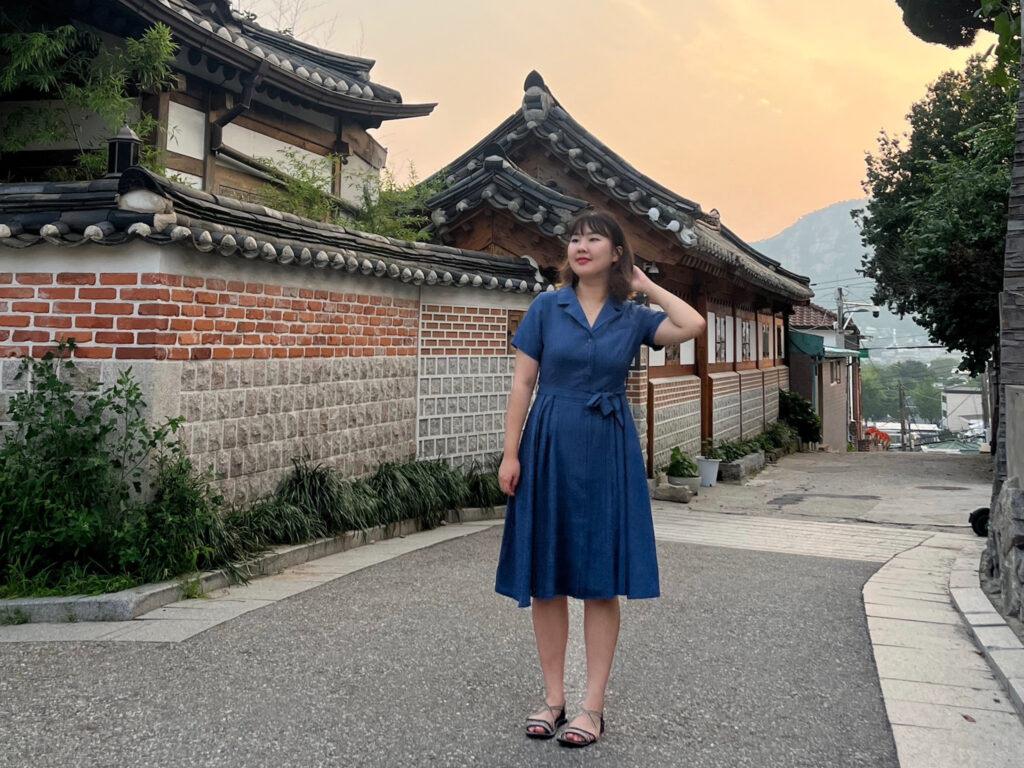 A student in a blue dress walks the streets of Korea.