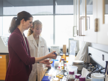 Female professor working with female student doing lab work