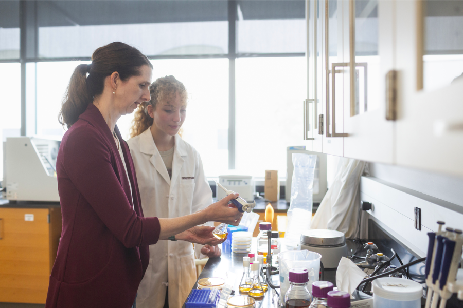 Female professor working with female student doing lab work