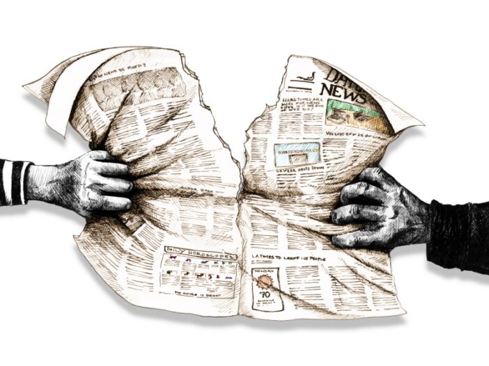 hands tearing newspaper apart (graphic)