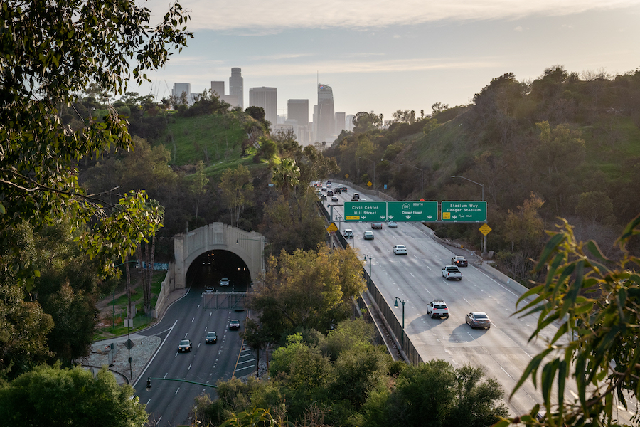 Traffic heads towards downtown Los Angeles in evening light.